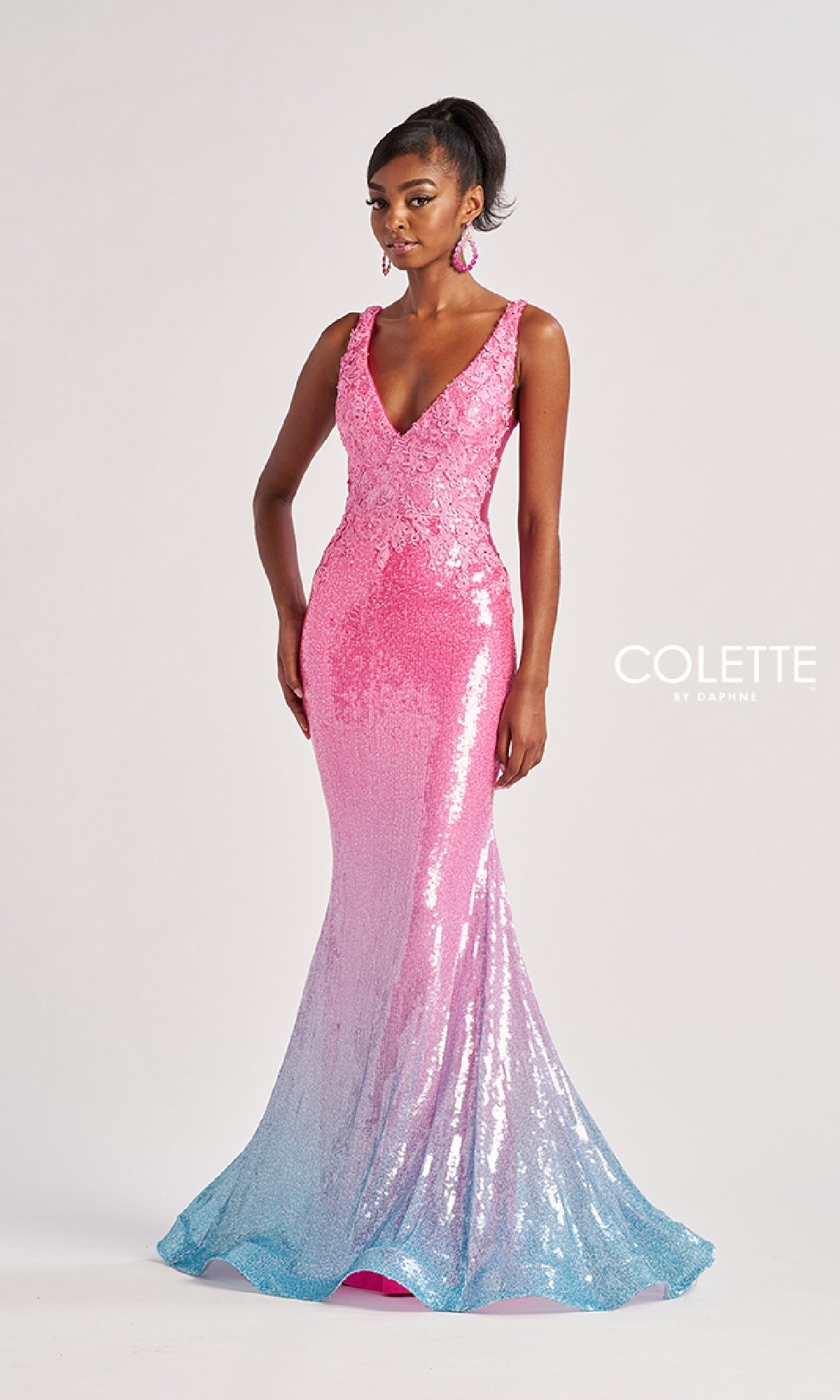 A woman wears the Colette CL8605 long prom dress, a sleeveless sequin mermaid gown with a deep V-neckline and pink-to-blue ombre, standing out beautifully against a plain background.